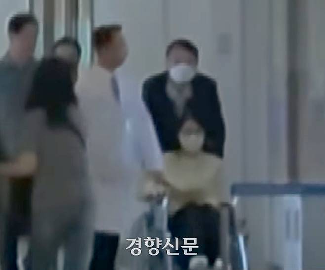 우울증 등으로 입원했던 김건희 여사가 27일 서울 아산병원에서 퇴원하고 있다. 윤석열 전 대통령이 김 여사의 휠체어를 밀고 있다. YTN 캡처