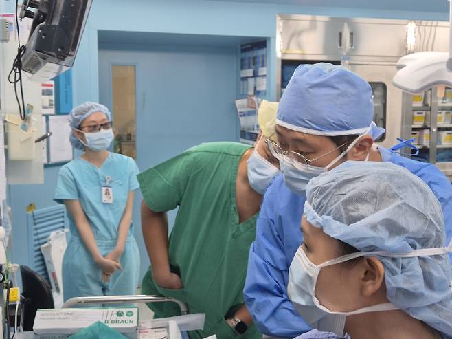 캄보디아 국립프레꼬사막병원 라따낫 치(Rattanak Chhy) 신장이식과 전문의(왼쪽에서 두 번째)가 23일 윤상철·권지은 순천향대서울병원 외과 교수가 집도한 신장이식 수술을 참관하고 있다. 순천향대서울병원 제공
