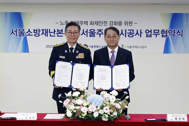 [서울=뉴시스] 황상하 SH공사 사장(오른쪽)과 권혁민 서울소방재난본부장이 협약 체결 후 협약서를 들어보이고 있다. 2025.06.27 (사진 제공=SH공사) photo@newsis.com *재판매 및 DB 금지