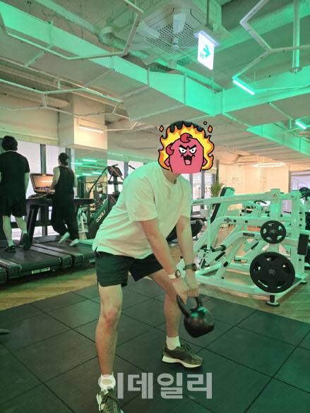 왼팔 손목에는 갤럭시워치7, 오른팔 손목에는 애플워치를 착용하고 캐틀벨 운동을 하고 있다(사진=윤정훈 기자)