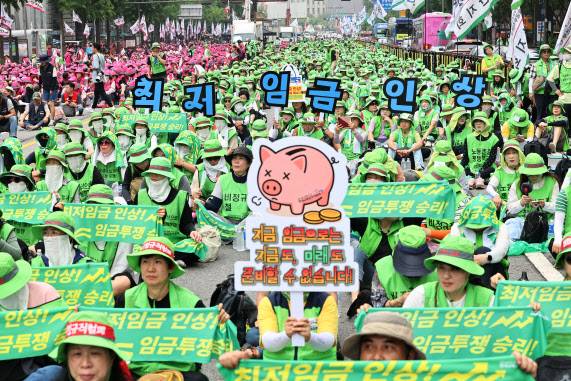 28일 서울 숭례문 인근에서 열린 ‘최저임금인상·노동기본권 쟁취 민주노총 결의대회’에서 참석자들이 관련 피켓을 들고 있다.(사진= 연합뉴스)