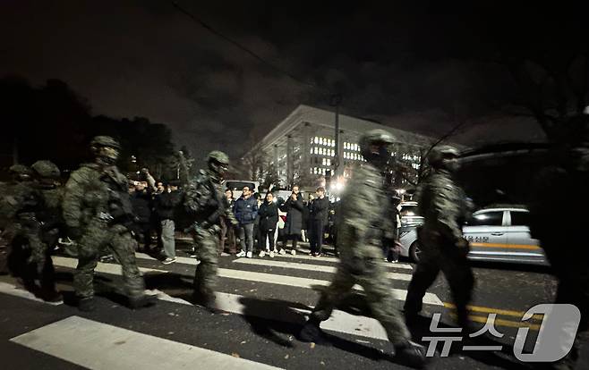 윤석열 대통령의 비상계엄 해제 요구 결의안이 국회 본회의에서 통과된 4일 새벽 무장 계엄군이 국회를 나서고 있다. 2024.12.4/뉴스1 ⓒ News1 안은나 기자
