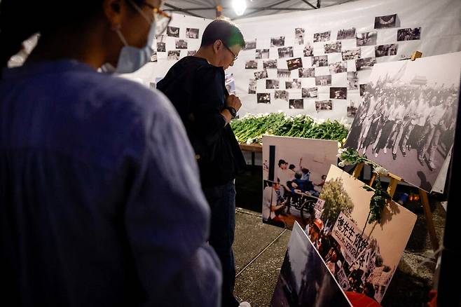 2025년 6월4일 대만 시민들이 천안문 사태 36주기를 맞아 타이베이 민주광장에 설치된 희생자 추모 분향소에서 1989년 당시 시위 사진을 보고 있다. REUTERS