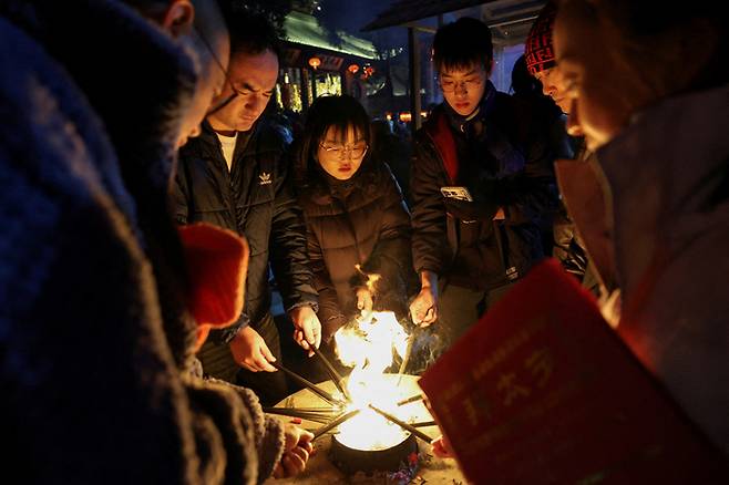 중국 베이징의 한 사찰에서 중국인들이 향에 불을 붙이는 모습 [사진 출처 = 로이터 연합뉴스]
