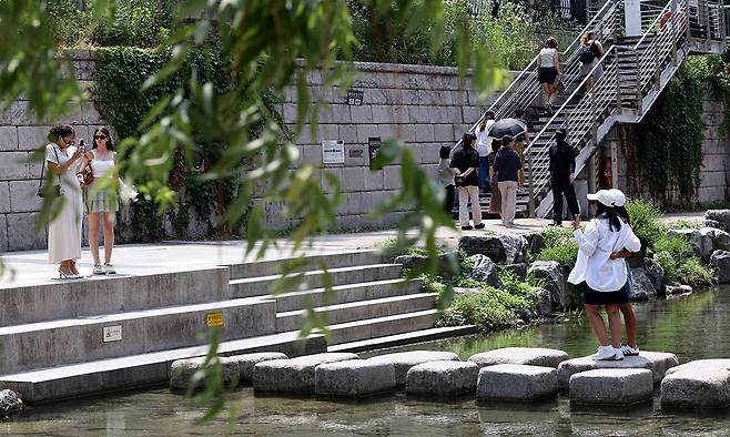 외국인 관광객들이 청계천 징검다리 위에서 기념사진을 찍고 있다.