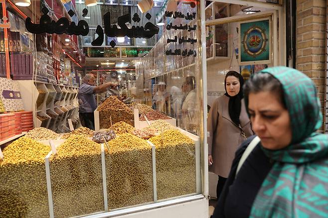 26일 이란과 이스라엘이 휴전을 약속한 이후 이란 테헤란의 재래시장인 타지리쉬 시장에서 장사를 다시 시작한 상인과 장을 보는 사람들 모습.