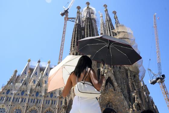 28일 스페인 바르셀로나에서 무더위를 피하기 위해 한 관광객이 우산을 두 개나 쓰고 있다. EPA=연합뉴스