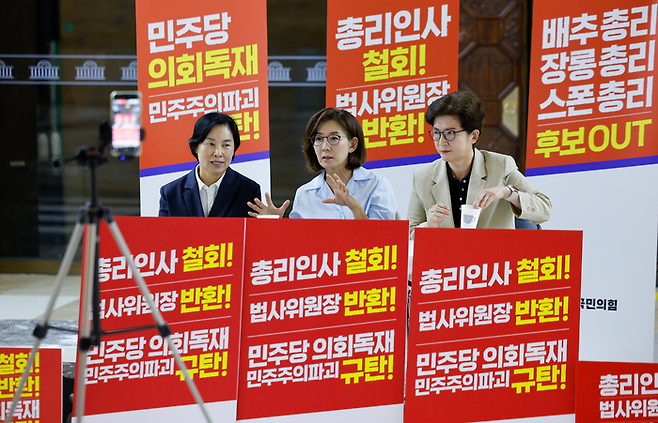 나경원 국민의힘 의원(가운데)이 29일 서울 여의도 국회 로텐더홀에서 김민석 국무총리 후보자 지명 철회와 법제사법위원장 야당 반환을 요구하며 철야농성을 하던 중 서명옥(왼쪽), 강선영 의원과 유튜브 라이브 방송을 하고 있다. <뉴스1>