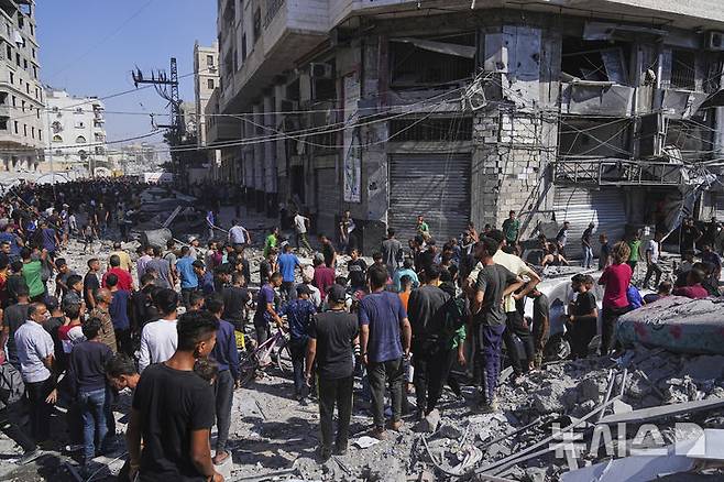 [가자시티=AP/뉴시스] 27일(현지 시간) 가자지구 가자시티에서 팔레스타인 주민들이 이스라엘의 공습으로 파손된 주거 건물 주변에 모여 있다. 2025.06.28.