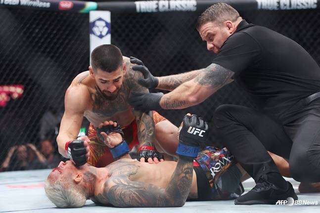 일리아 토푸리아(왼쪽 위)가 찰스 올리베이라(아래)에게 파운딩을 시도하고 있다. /AFPBBNews=뉴스1