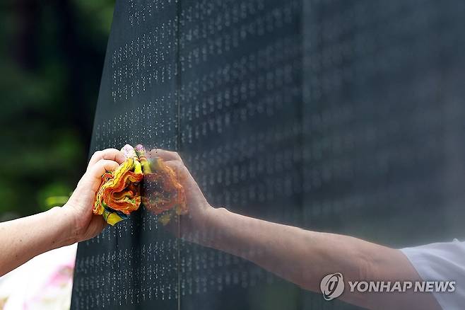 삼풍백화점 붕괴 참사 30주기 (서울=연합뉴스) 신현우 기자 = 삼풍백화점 붕괴 참사 30주기인 29일 서울 서초구 매헌시민의숲 삼풍참사위령탑을 찾은 유족이 희생자를 추모하며 희생자 이름이 새겨진 위령탑을 손수건으로 닦고 있다. 2025.6.29 nowwego@yna.co.kr