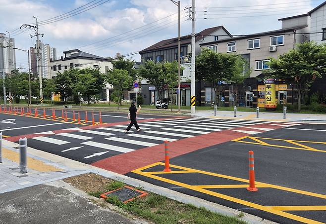 고원식 횡단보도를 건너는 보행자. 달성군이 회전교차로 설치와 함께 기존 횡단보도를 고원식으로 교체해 차량의 자연 감속을 유도하고 있다. 보행자 안전을 고려한 설계로 현장 체감 효과도 높다는 평가다.<달성군 제공>