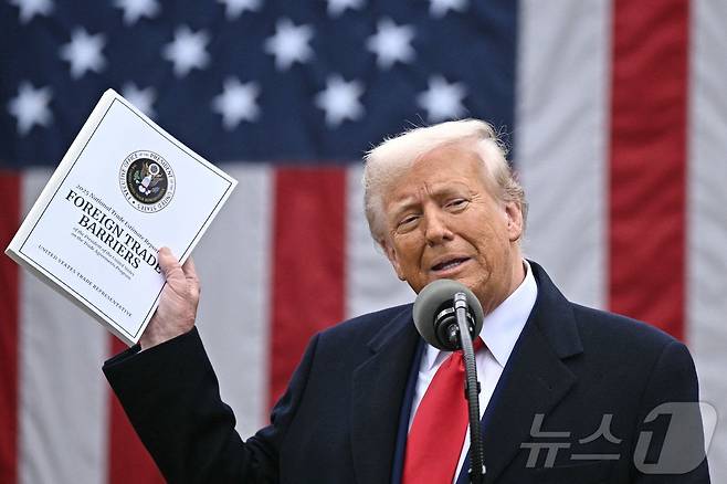 도널드 트럼프 미국 대통령이 2일(현지시간) 워싱턴 백악관 로즈가든에서 열린 ‘미국을 다시 부유하게’ 행사서 상호관세를 발표하며 최신 무역장벽 보고서를 들고 "오늘은 미국 역사에서 가장 중요한 날 중 하나인 미국 해방의 날＂이라고 말하고 있다. 2025.04.03 ⓒ AFP=뉴스1 ⓒ News1 우동명 기자