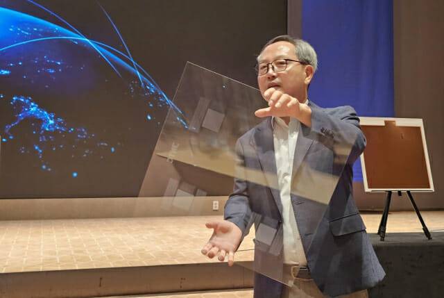 장상욱 제이앤티그룹 회장이 제이앤티씨가 자체 개발한 유리기판 시제품을 선보이고 있다(사진=장경윤 기자)