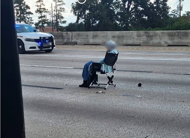 A씨가 도로 한복판에 총을 들고 나와 앉은 모습. /페이스북