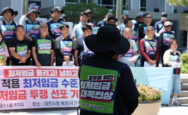 민주노총 대전지역본부 조합원들이 지난 11일 대전시청 앞에서 기자회견을 열고 2026년 최저임금 대폭 인상을 촉구하고 있다. 이들은 2026년 적용 최저임금을 시급 1만1500원(월 209시간 기준 240만3500원)을 요구했다./뉴스1
