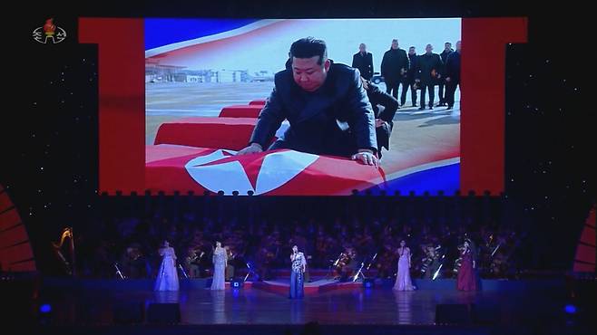 북한 조선중앙TV는 30일 북한 김정은 국무위원장이 올가 류비모바 러시아 문화부 장관 일행과 전날 4·25문화회관에서 관람한 북한 예술단 공연 무대 배경 화면에 김정은이 러시아 파병 북한군 전사자 관을 어루만지며 애도하는 모습이 담긴 장면을 내보냈다. /조선중앙TV 캡처