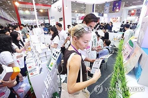 지난 5월 28일 서울 강남구 코엑스에서 열린 2025 서울국제화장품미용산업박람회 및 국제건강산업박람회를 찾은 외국인 바이어와 관람객들이 제품을 살펴보고 있다. [연합뉴스]