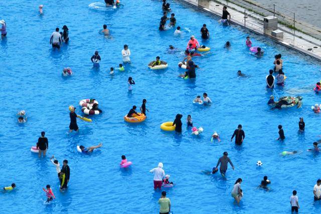 서울 한낮 기온이 30도까지 오르며 더운 날씨를 보인 29일 서울 마포구 난지 한강공원 물놀이장에서 시민들이 물놀이를 즐기고 있다. 수영장은 수족구병의 감염 통로이기도 하다. 연합뉴스