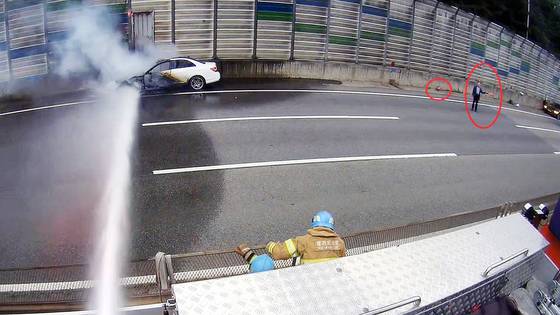 지난 24일 오후 경기도 성남시 분당수서간 고속화도로에서 분당방향으로 주행중이던 벤츠 차량에서 불이 났다. 당시 한 시민이 소화기로 화재 진압을 한 뒤 신호봉으로 교통 통제를 했는데 제27대 성남소방서 서장을 지낸 이점동씨로 확인됐다. 동그라미 속 차량 진입을 막는 사람이 이점동 전 서장이다. 사진 경기도소방재난본부