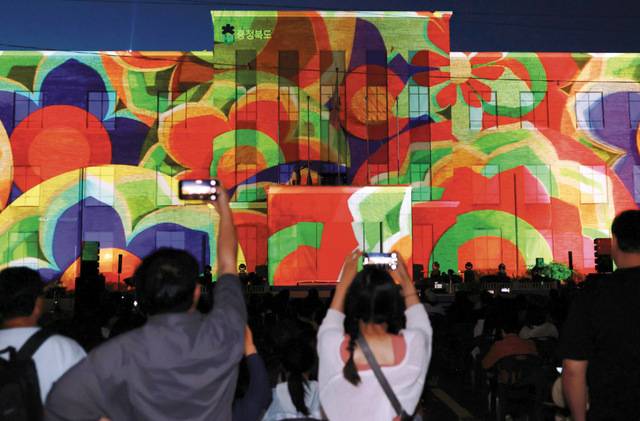 시민들이 충북도청 본관에 상영되고 있는 초대형 미디어파사드를 휴대전화로 촬영하고 있는 모습. 충북도 제공