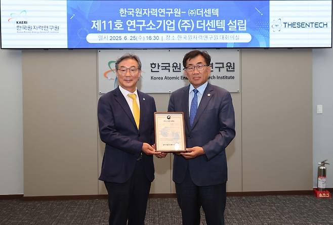 주한규(오른쪽) 한국원자력연구원장과 김경호 더센텍 대표이사가 연구소기업 설립 인증서를 들고 기념촬영을 하고 있다.[한국원자력연구원 제공]