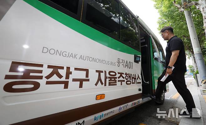 [서울=뉴시스] 조성우 기자 = '지역동행 자율주행버스'가 사전 운행을 시작한 30일 서울 동작구 숭실대학교 앞 정류장에서 관계자가 버스를 타고 있다.'지역동행 자율주행버스'는 자치구 단위 마을버스 성격으로 동작구에 최초로 도입되어 이날부터 2주간 사전 운행 후 오는 7월 14일부터 정식 운행한다.   2025.06.30. xconfind@newsis.com