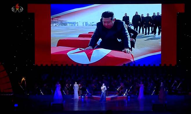 북한 조선중앙TV가 지난 29일 동평양대극장에서 방북 중인 올가 류비모바 러시아 문화부 장관이 참석한 가운데 열린 예술인 공연 중 무대 배경화면에 김정은 국무위원장이 러시아 파병 북한군 전사자 관을 어루만지며 애도하는 장면을 30일 공개했다. 조선중앙TV화면 캡처