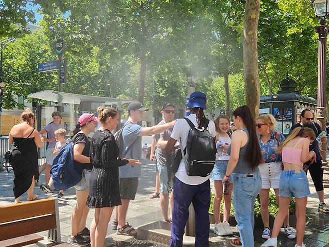 쿨링포그로 더위 식히는 사람들 (파리=연합뉴스) 송진원 특파원 = 30일(현지시간) 오후 2시께 프랑스 파리 샹젤리제 거리 한복판에 설치된 음수대 및 쿨링포그 주변에 사람들이 몰려 있다. san@yna.co.kr 2025.06.30