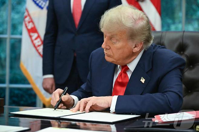 도널드 트럼프 미국 대통령이 6월 27일 백악관 집무실에서 르완다와 콩고민주공화국의 평화 협정을 축하하는 내용의 서한에 서명하고 있다. 2025.6.27 ⓒ AFP=뉴스1 ⓒ News1 강민경 기자