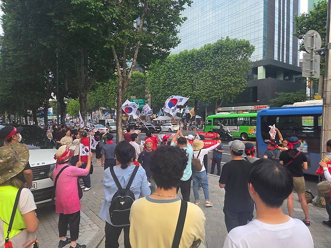 28일 오후 서울 서초구 서초대로에서 윤석열 전 대통령의 지지자들이 촛불행동의 집회 참가자들을 향에 태극기를 흔들고 있다./김도연 기자