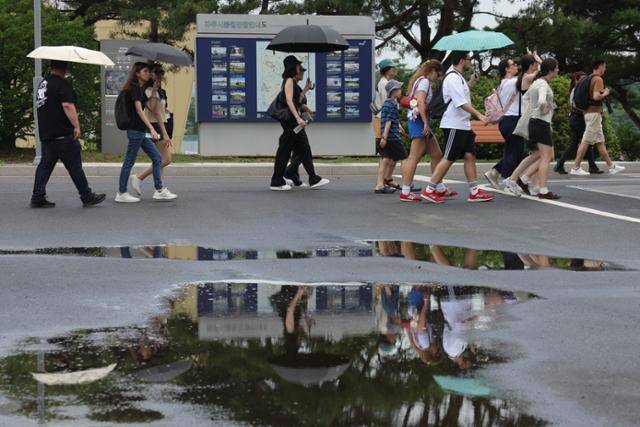 1일 경기도 파주시 임진각에서 관광객들이 양산을 든 채 장맛비로 젖은 땅을 걷고 있다. 연합뉴스