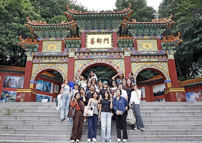 Students on June 27 take a photo infront of a paeru, or main gate, that connects the Jayu Park and Incheon Chinatown. [PARK SANG-MOON]