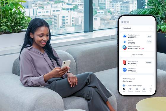 A woman uses a Toss application on her phone in this promotional photo provided by the payment services company. [TOSS]