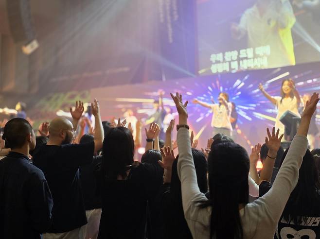 저녁 집회 참가자들이 30일 경기도 안양 새중앙교회 대예배당 무대 앞으로 나와 손 들고 찬양하고 있다.