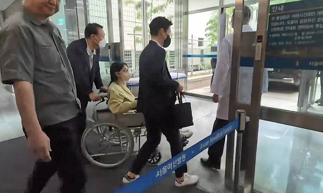 6월27일 김건희씨가 남편 윤석열씨가 미는 휠체어에 탄 채 서울아산병원을 퇴원하고 있다. ⓒSBS·MBC·KBS·YTN·MBN 방송 풀