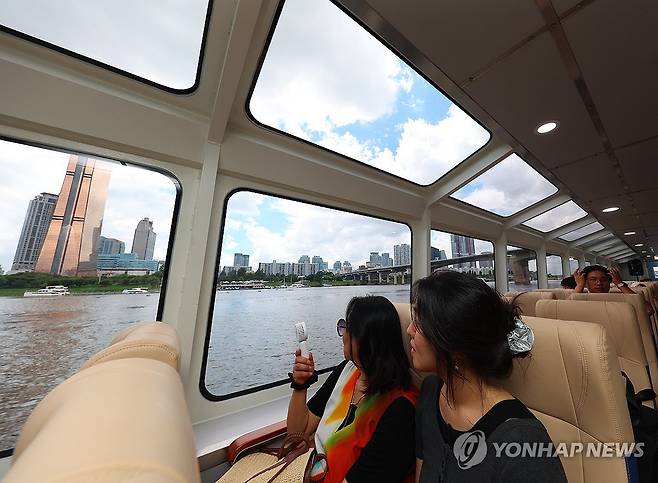 한강버스에서 바라보는 여의도 (서울=연합뉴스) 김도훈 기자 = 1일 정식 취항을 앞두고 시범운항에 나선 한강버스에 탑승한 시민들이 여의도 일대를 바라보고 있다.
    한강 유역에 처음 도입되는 친환경 수상 대중교통수단인 한강버스는 9월 중 정식운항을 통해 마곡~망원~여의도~옥수~압구정~뚝섬~잠실(마곡~여의도~잠실 급행 병행 운영) 7개 선착장, 약 31.5km의 거리를 운항할 예정이다. 2025.7.1 superdoo82@yna.co.kr