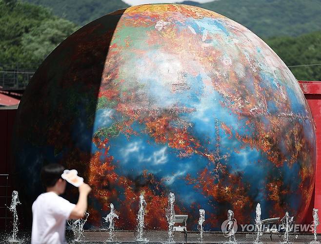 '올여름 얼마나 뜨거울까' (대구=연합뉴스) 윤관식 기자 = 전국 대부분 지역에 폭염특보가 발효 중인 1일 대구 동구 대구시민안전테마파크에 설치된 불타는 지구 조형물 앞으로 분수대가 가동되고 있다. 대구에서는 전날 일평균 기온이 30.7도를 기록하며 1907년 1월 관측 이래 역대 6월 중 가장 더웠다. 2025.7.1 psik@yna.co.kr