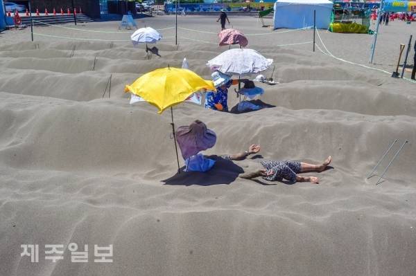 삼양검은모래해변에서 피서객들이 찜질을 하는 모습. 고봉수 기자