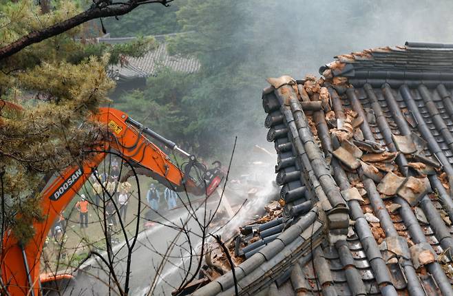 지난달 30일 오후 화재가 발생한 서울 성북구 명승 제118호 ‘성북동 별서’ 내 목조 건물 송석정에서 소방당국이 중장비로 기와지붕을 무너뜨리며 진화 작업을 벌였다. 뉴시스