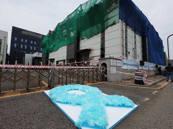 지난달 24일 경기도 화성시 아리셀 화재 사고 현장에서 열린 '아리셀 참사 1주기 현장 추모 위령제'에 파란 리본 모양의 꽃이 놓여 있다. 연합뉴스