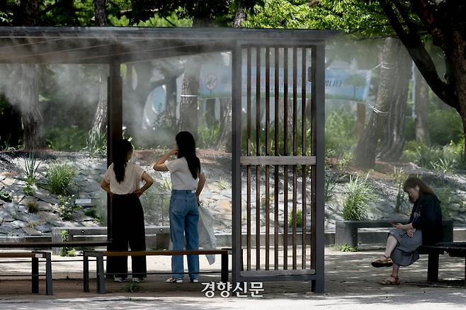 서울의 한낮 체감온도가 33도까지 오르는 등 무더위가 이어지고 있는 지난 1일 서울 여의도공원에서 시민들이 쿨링포그 벤치에 앉아 더위를 피하고 있다. 문재원 기자