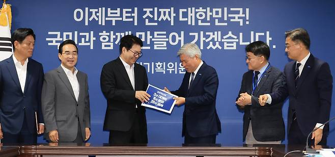 이한주 국정기획위원장이 2일 서울 종로구 국정기획위원회에서 조국혁신당 원내대표단 접견에 앞서  서왕진 원내대표로부터 정책과제를 전달받고 있다. 연합뉴스