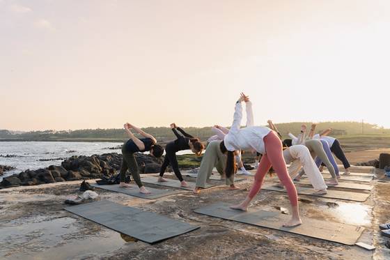 A picture of tourists enjoying yoga by the beach in Jeju Island [JEJU TOURISM ORGANIZATION]