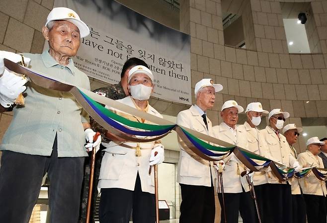 지난 20일 오후 서울 용산구 전쟁기념관 중앙홀에서 열린 ‘우리는 그들을 잊지 않았다’ 국군포로존 개막식에서 유영복 옹을 비롯한 국군포로 유공자들이 리본 커팅을 하고 있다. [사진 = 뉴스1]