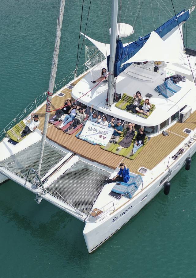 지난달 18일 경남 통영시 산양읍에 자리한 이운항과 용호도를 오가는 요트 위에서 관광객들이 손을 흔들고 있다. 백동현 기자