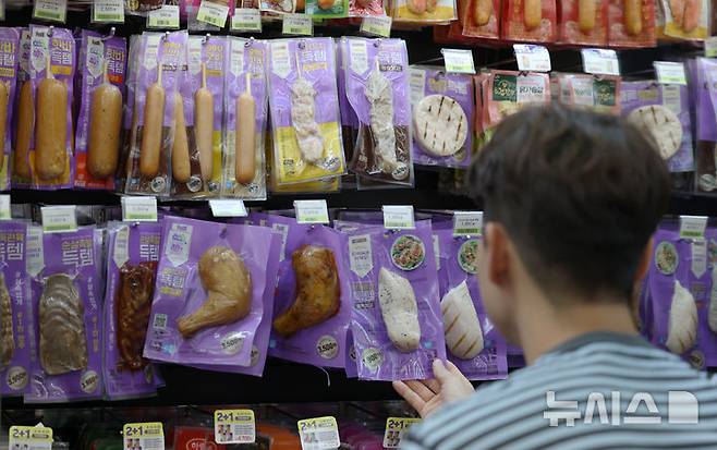 [서울=뉴시스] 조성우 기자 = 25일 서울의 한 CU 편의점에서 시민이 CU 자체브랜드(PB) 상품인 '득템 닭가슴살'을 살펴보고 있다. 2025.06.25. xconfind@newsis.com