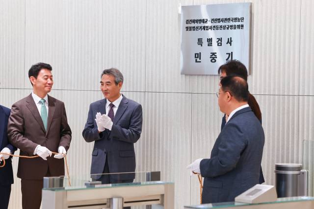 윤석열 전 대통령 부인 김건희 여사와 관련한 각종 의혹 사건을 수사하는 민중기 특별검사가 2일 서울 종로구 KT광화문빌딩에 마련된 사무실 앞에서 현판 제막을 한 뒤 박수를 치고 있다. 연합뉴스