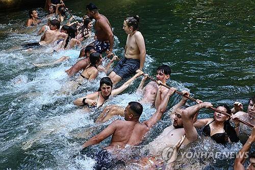 1일 독일 뮌헨의 개울에 뛰어든 피서객 [epa 연합뉴스 자료사진]