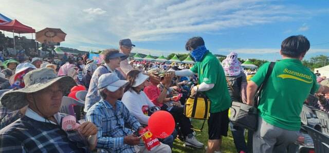 지난 7월 1일, 군위둔치 생활체육공원에서 열린 군부대 이전 기념 싱싱코리아 행사에서 행사장을 찾아 무더위에 지친 주민들에게 새마을 회원들이 시원한 아이스크림, 생수 등을 나눠주며 안부를 살피고 있다.새마을회 제공.